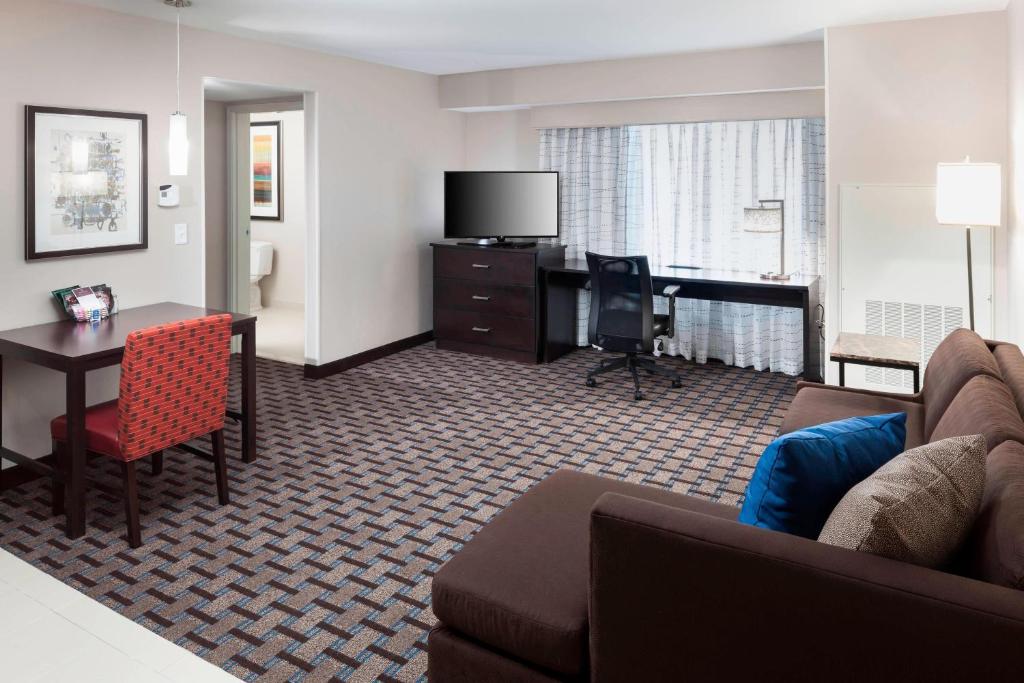 a hotel room with a couch and a table and a desk at Residence Inn by Marriott Dallas Plano/Richardson in Plano