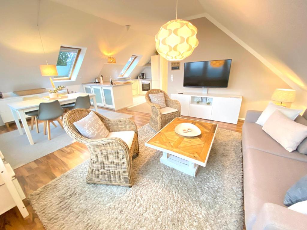ein Wohnzimmer mit einem Sofa, Stühlen und einem Tisch in der Unterkunft Kieler FeWo No.1 in Kiel