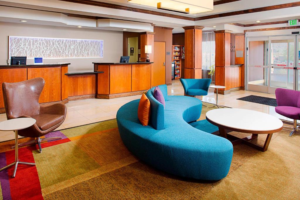 a lobby with a blue couch and a table and chairs at Fairfield Inn and Suites by Marriott Dallas Mansfield in Mansfield