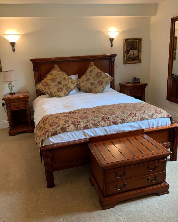 ein Schlafzimmer mit einem Bett, zwei Nachttischen und zwei Tischen in der Unterkunft The Down Inn in Bridgnorth