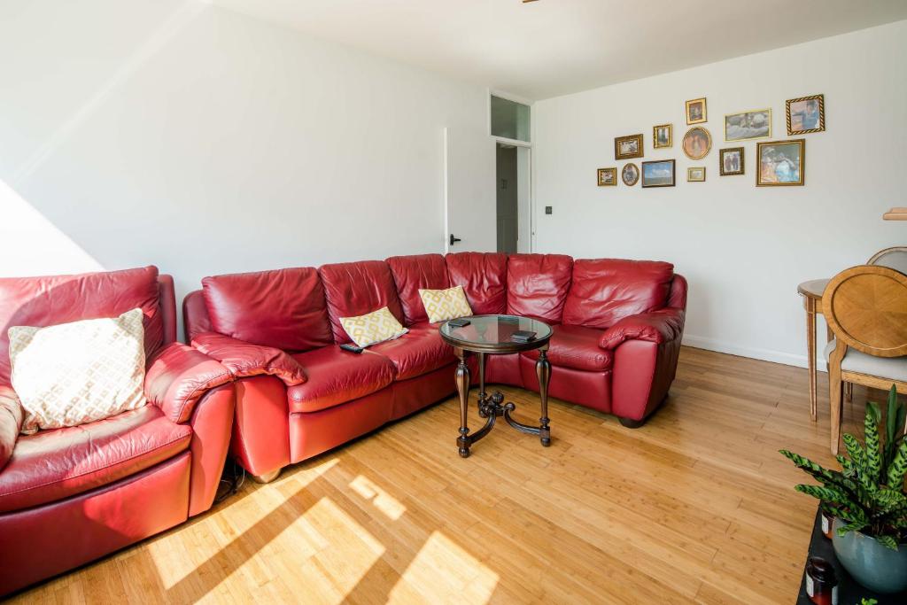 uma sala de estar com um sofá vermelho e uma mesa em Delightful Stay For 2 in Islington em Londres