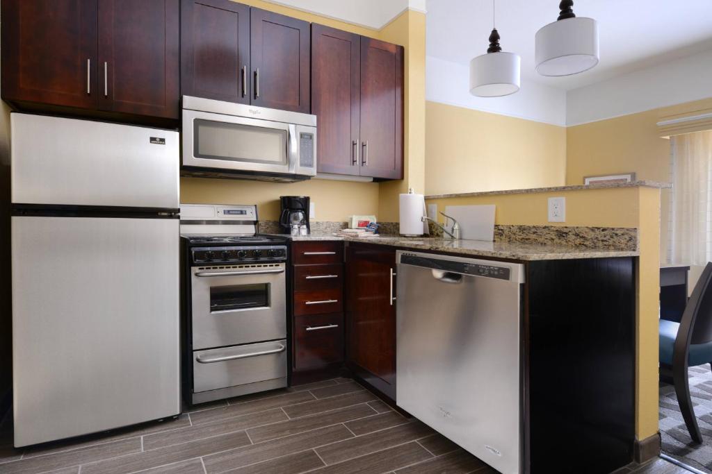 a kitchen with stainless steel appliances and wooden cabinets at TownePlace Suites by Marriott Laredo in Laredo