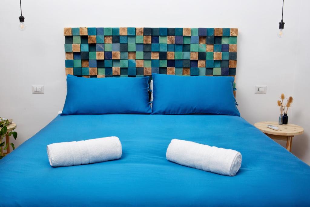 un letto blu con due cuscini bianchi sopra di B&B Miseno23 a Bacoli