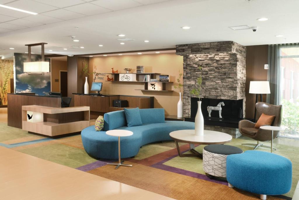 a living room with a blue couch and a fireplace at Fairfield Inn & Suites by Marriott Fort Worth South/Burleson in Burleson