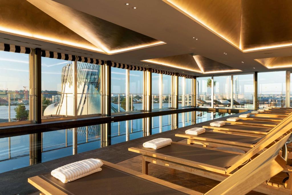 una fila de mesas en una habitación con ventanas en Renaissance Bordeaux Hotel, en Burdeos