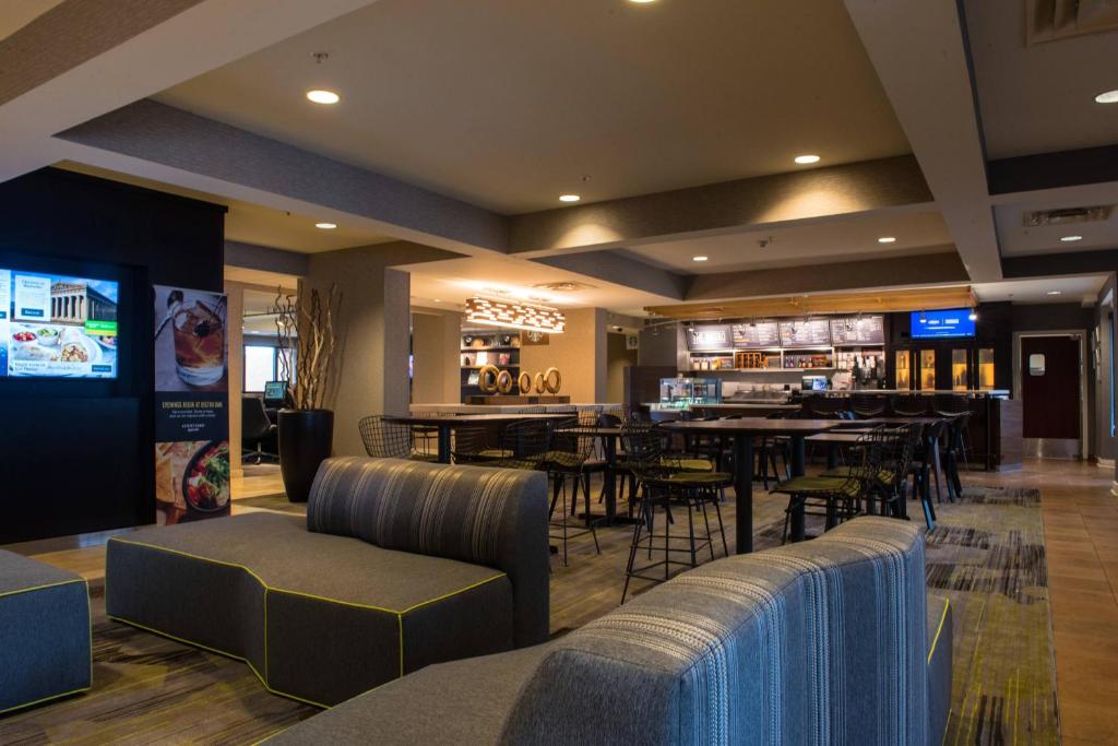 a restaurant with tables and chairs and a bar at Courtyard by Marriott Nashville at Opryland in Nashville