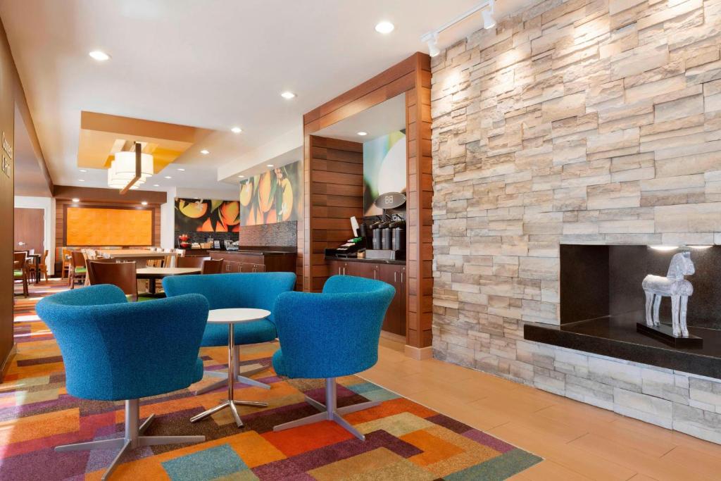 a lobby with blue chairs and a fireplace at Fairfield Inn & Suites Longview in Longview