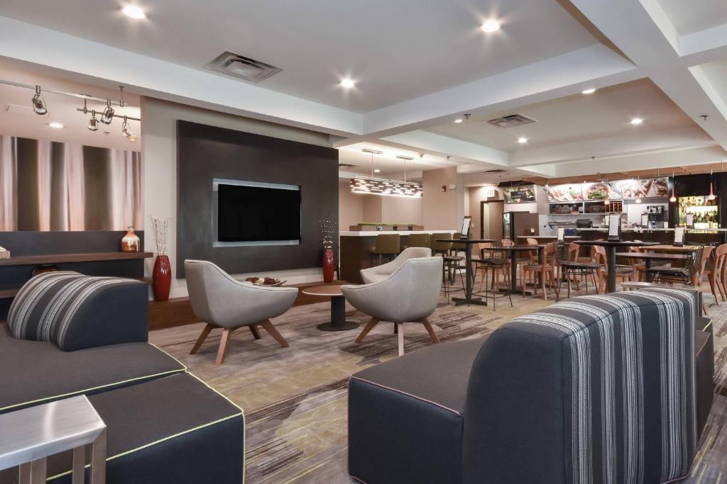 a hotel lobby with chairs and a dining room at Courtyard by Marriott Charlotte Lake Norman in Huntersville