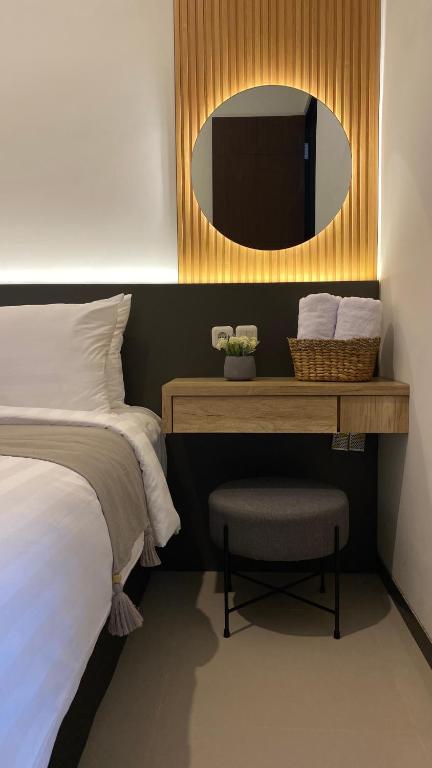a bedroom with a bed and a desk with a television at The Pinasti Villas in Tlekung