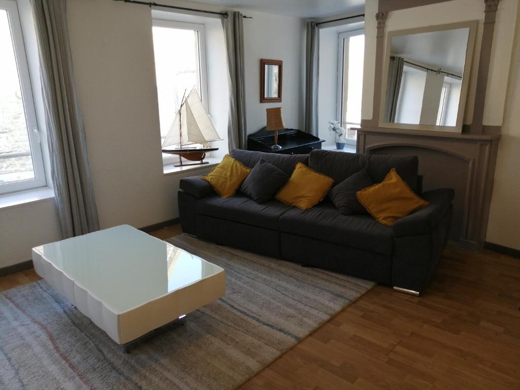 ein Wohnzimmer mit einem schwarzen Sofa und einem Couchtisch in der Unterkunft Mer&Campagne Wimille in Wimille