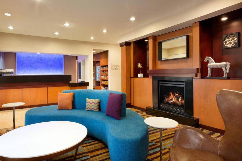 sala de estar con sofá azul y chimenea en Fairfield Inn & Suites Dallas Mesquite, en Mesquite