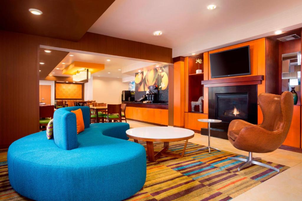 sala de estar con sofá azul y chimenea en Fairfield Inn & Suites by Marriott Houston Energy Corridor/Katy Freeway, en Houston