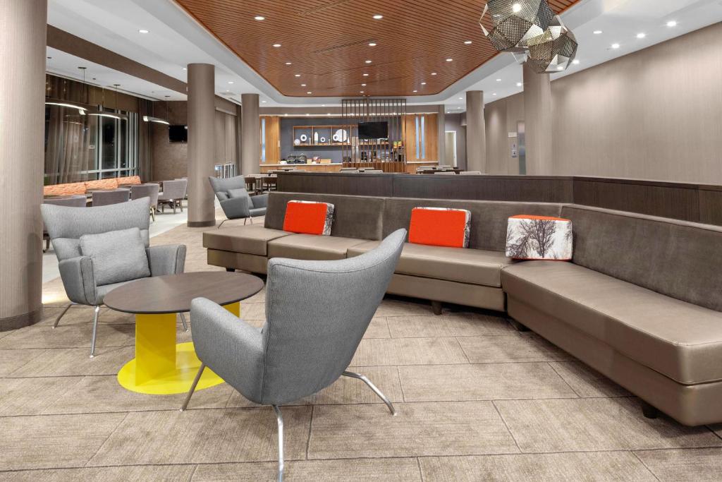 a lobby with a waiting area with tables and chairs at SpringHill Suites by Marriott Denver Tech Center in Greenwood Village