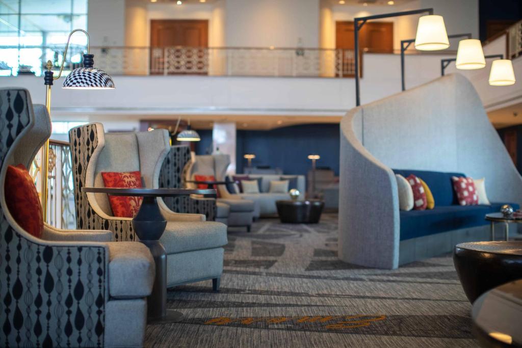 eine Lobby mit Sofas und Stühlen in einem Gebäude in der Unterkunft Renaissance Concourse Atlanta Airport Hotel in Atlanta