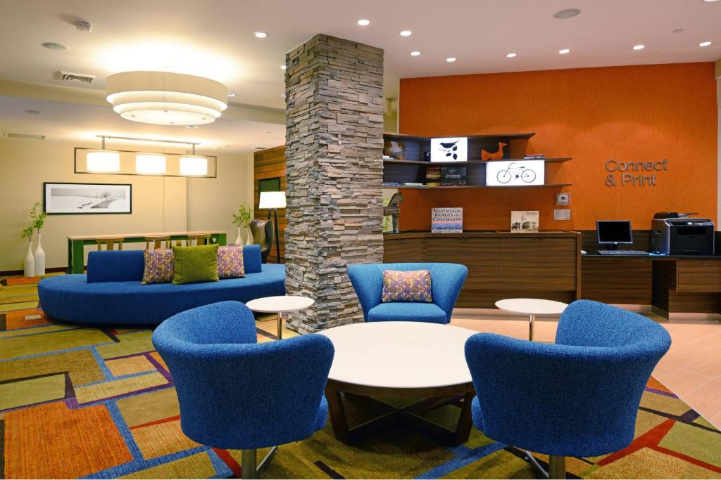 a lobby with blue chairs and a waiting room at Fairfield Inn & Suites Denver Cherry Creek in Denver