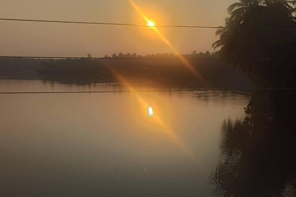 un amanecer sobre un cuerpo de agua con la puesta de sol en Ocean Pearl, en Kozhikode