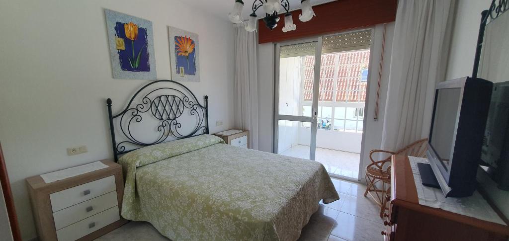 1 dormitorio con 1 cama y TV de pantalla plana en Casa Camila en Portonovo, en Sanxenxo