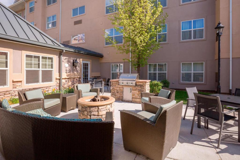 Residence Inn Boise West في بويز: فناء فيه كراسي وشواية امام مبنى