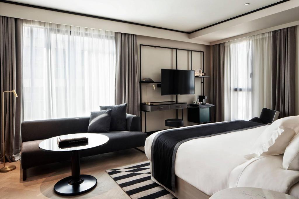 a hotel room with a bed and a couch at Academias Hotel, Autograph Collection in Athens