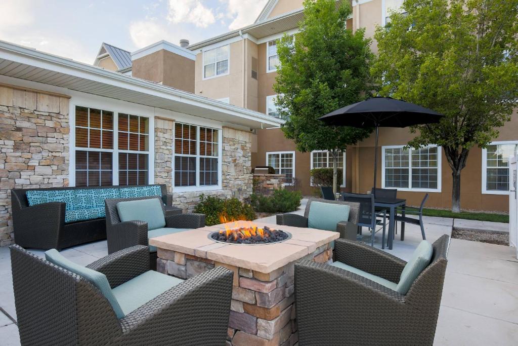 a patio with a table and chairs and an umbrella at Residence Inn by Marriott Albuquerque North in Albuquerque