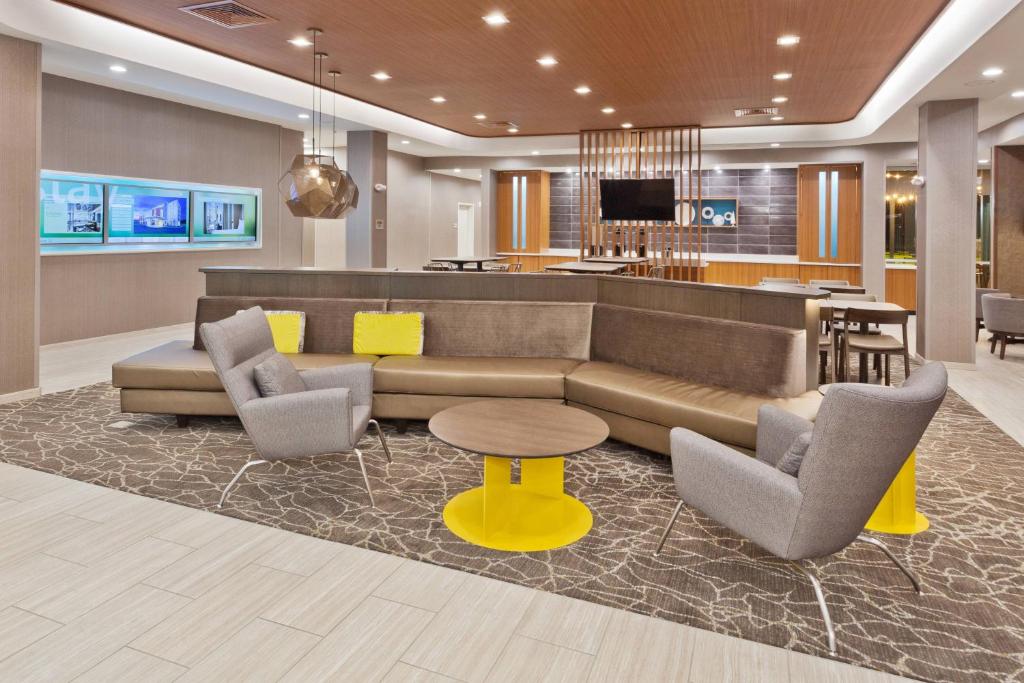a lobby with a couch and chairs and a bar at SpringHill Suites by Marriott Montgomery Prattville/Millbrook in Millbrook