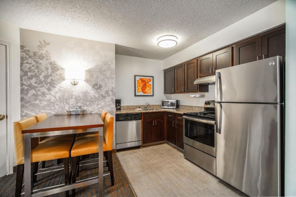 a kitchen with a table and a stainless steel refrigerator at Residence Inn by Marriott McAllen in McAllen