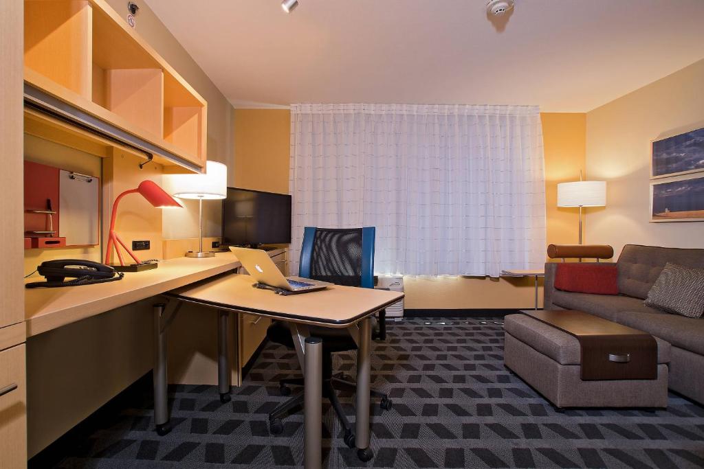 a hotel room with a desk with a laptop on it at TownePlace Suites by Marriott Dodge City in Dodge City