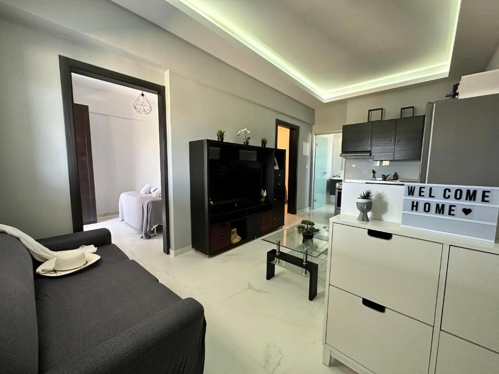 een woonkamer met een bank en een televisie bij Nisos Family House in Perama
