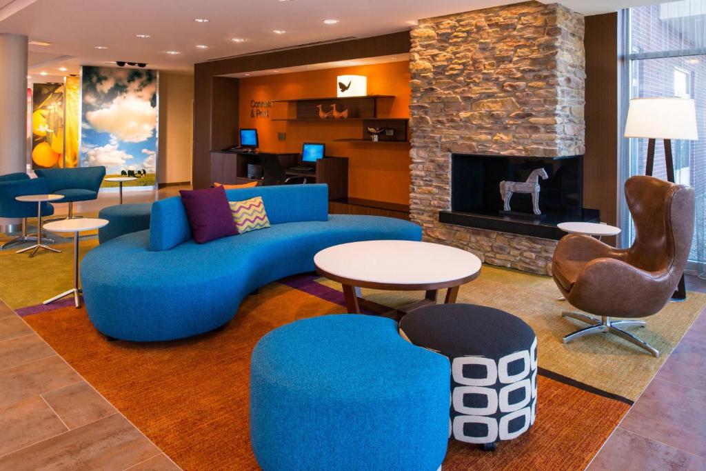 a living room with a blue couch and a fireplace at Fairfield Inn & Suites by Marriott Akron Stow in Stow