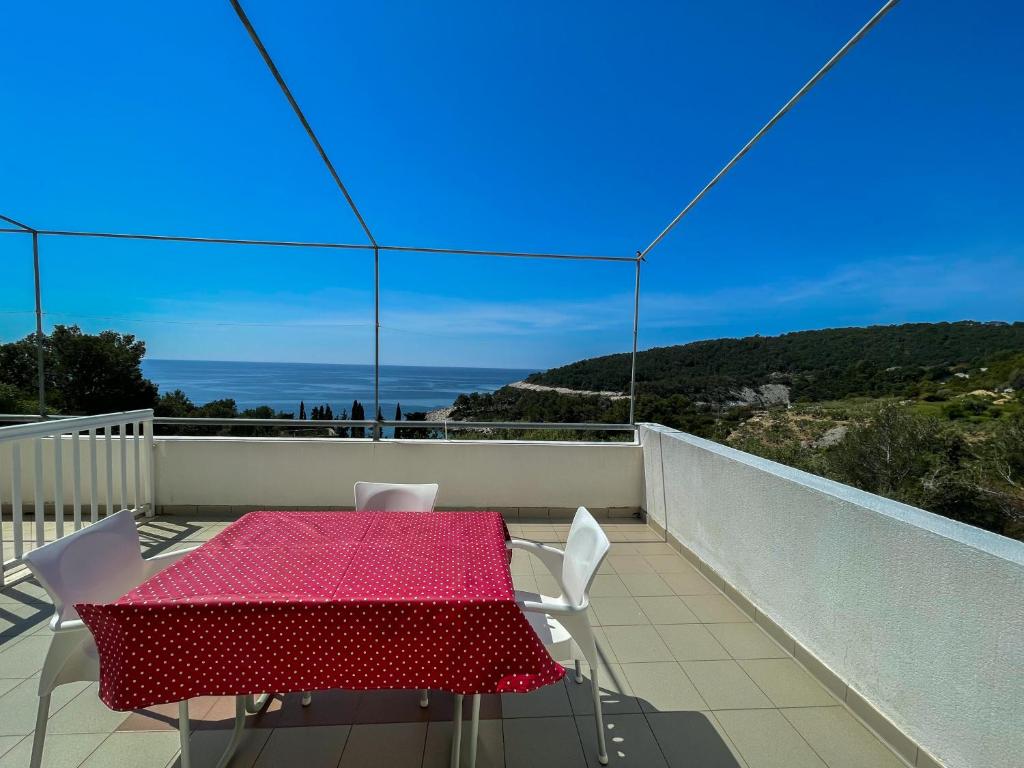 a table and chairs on a balcony with a view of the ocean at Apartments Marija Magdalena in Hvar