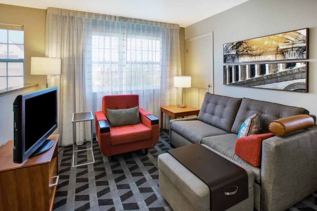 a living room with a couch and a tv at TownePlace Suites by Marriott Detroit Livonia in Livonia