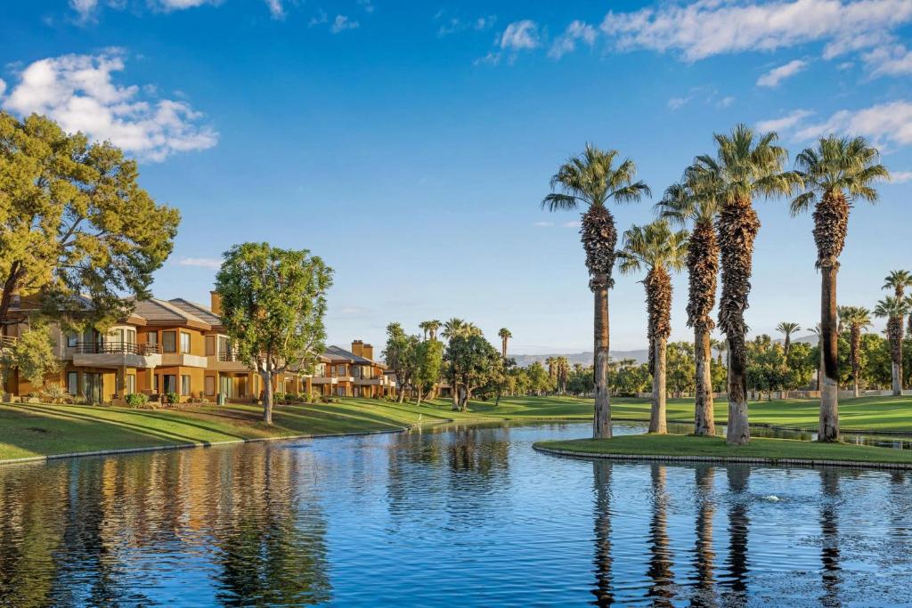 a pond with palm trees in front of a house at Marriott's Desert Springs Villas I in Palm Desert