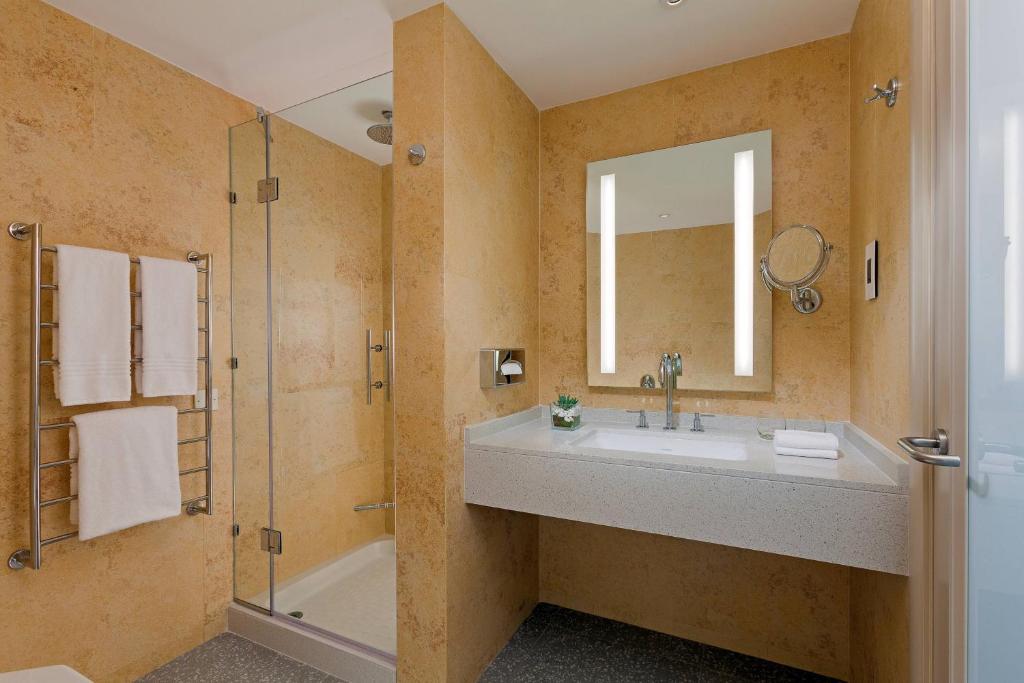 a bathroom with a sink and a shower at Malta Marriott Resort & Spa in St. Julianʼs