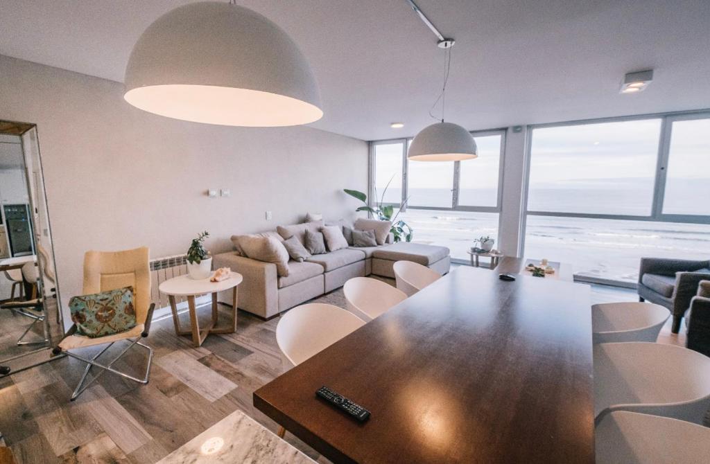 sala de estar con sofá, mesa y sillas en Frente al mar 110 m2 en Monte Hermoso