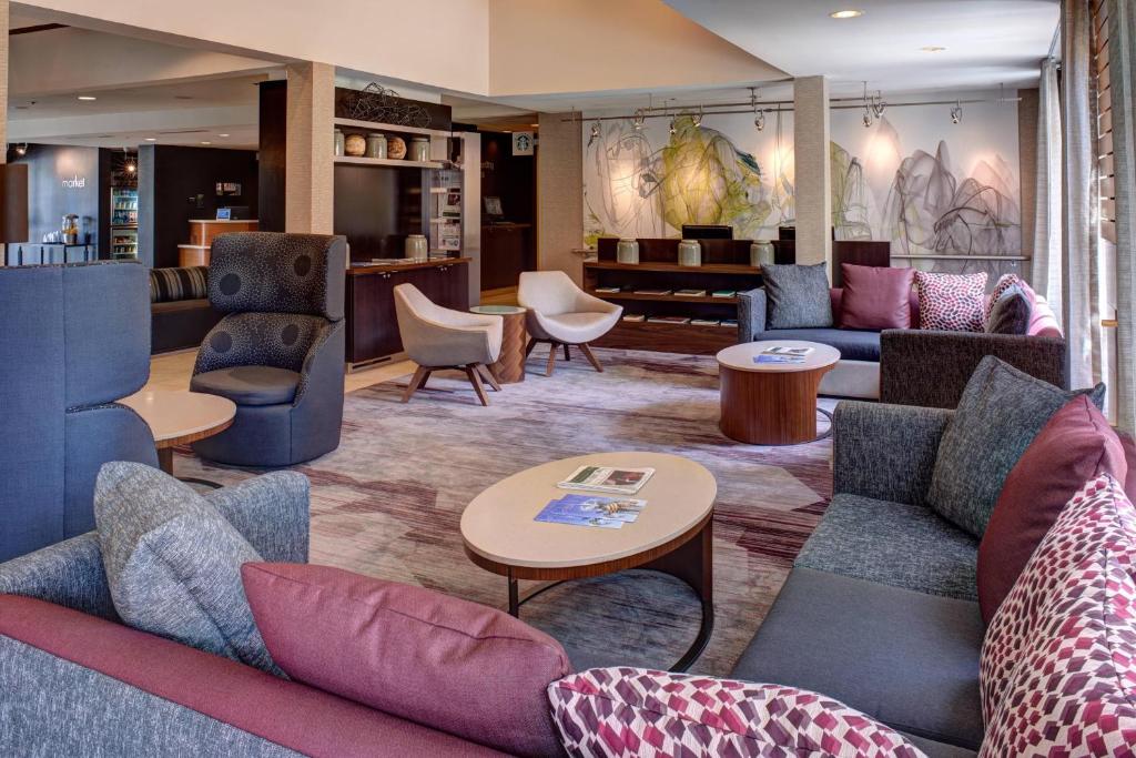 a lobby with couches and chairs and a table at Courtyard Des Moines West/Clive in Clive