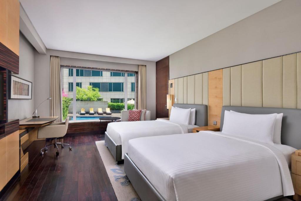 a hotel room with two beds and a living room at JW Marriott Hotel New Delhi Aerocity in New Delhi