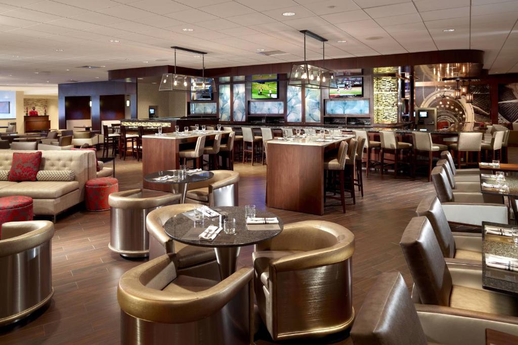 a restaurant with tables and chairs and a bar at Atlanta Airport Marriott in Atlanta