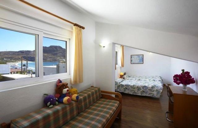 un soggiorno con divano, letto e finestra di Morpheas Apartments a Plakiás