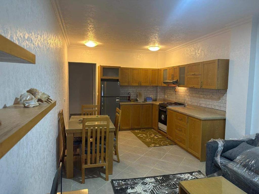 沙姆沙伊赫的住宿－Chillax The View Resort，厨房配有木制橱柜、桌子和沙发。