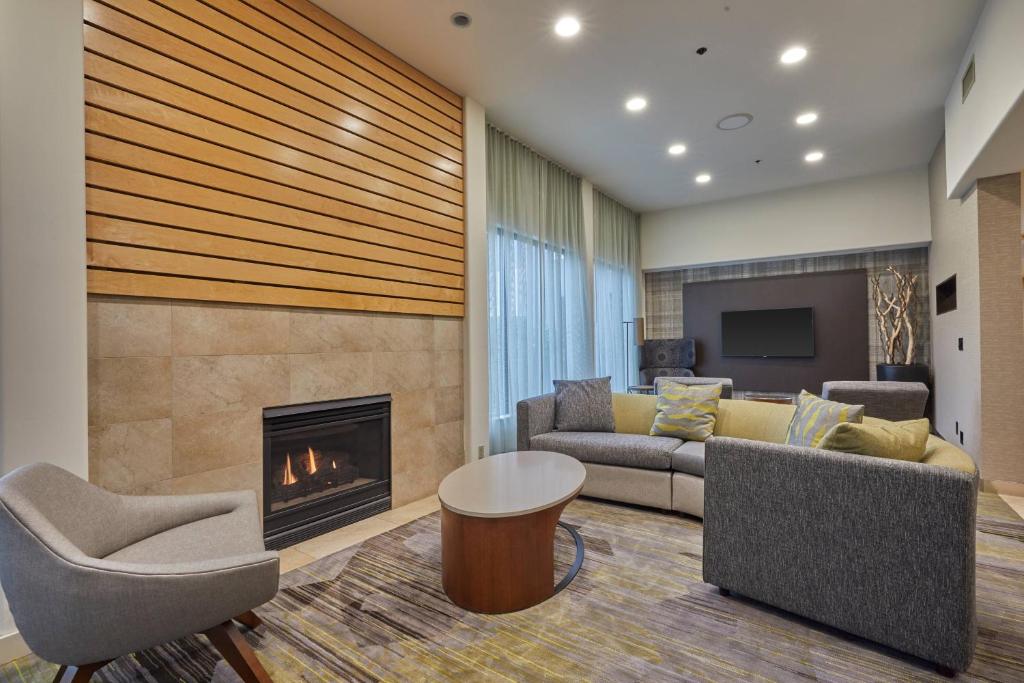 a living room with a couch and a fireplace at Courtyard by Marriott Eugene Springfield in Springfield