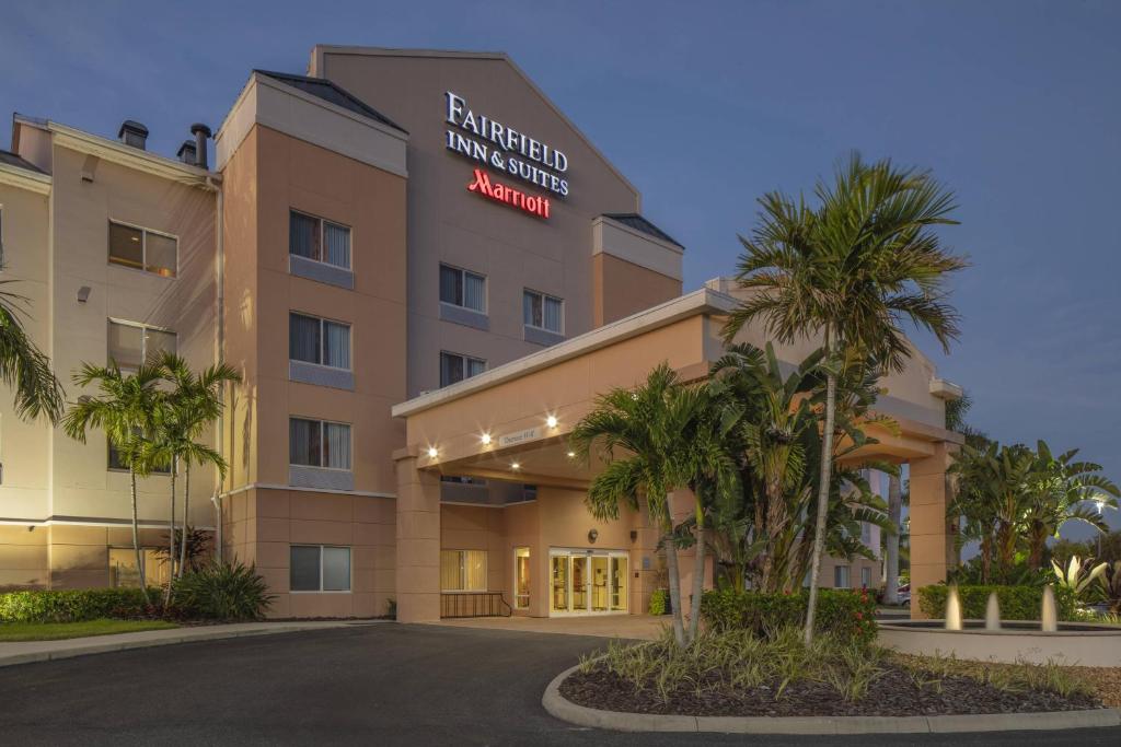 a hotel with palm trees in front of a building at Fairfield Inn & Suites by Marriott Venice in Venice