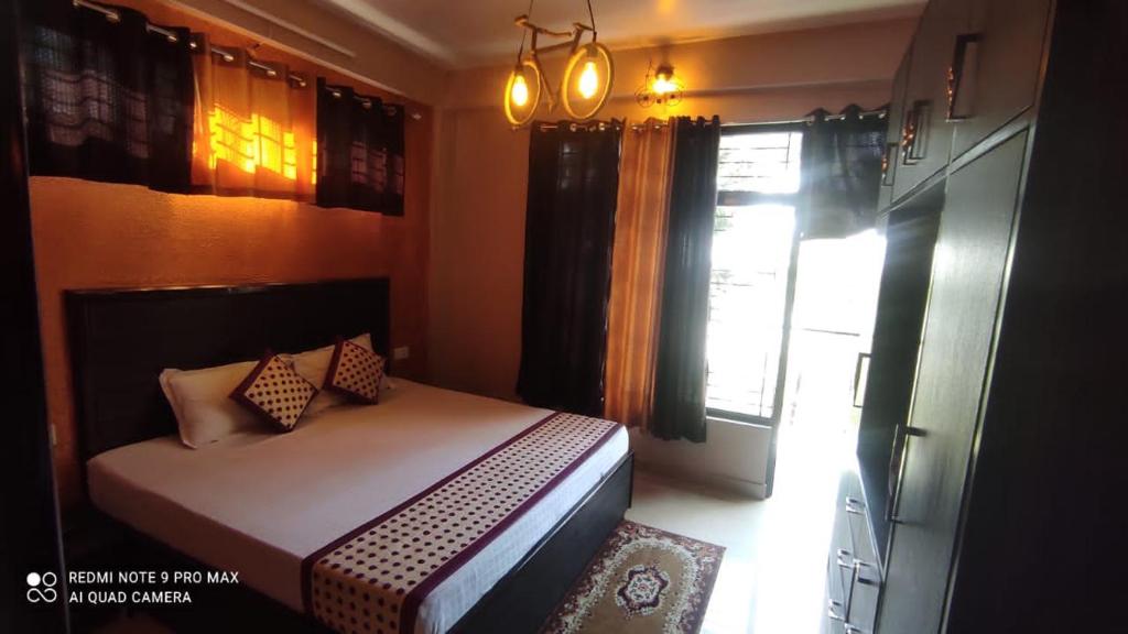 um pequeno quarto com uma cama e uma janela em Puri's BnB em Shimla
