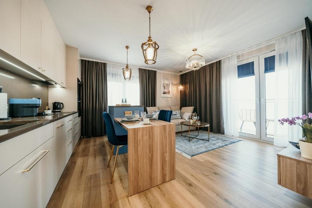 een keuken en een woonkamer met een tafel en stoelen bij Apartament Talaso in Puck