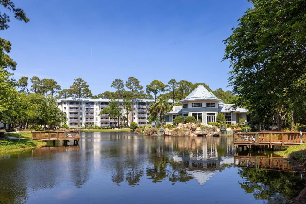 a large building sitting next to a river with a house at Marriott's SurfWatch in Hilton Head Island