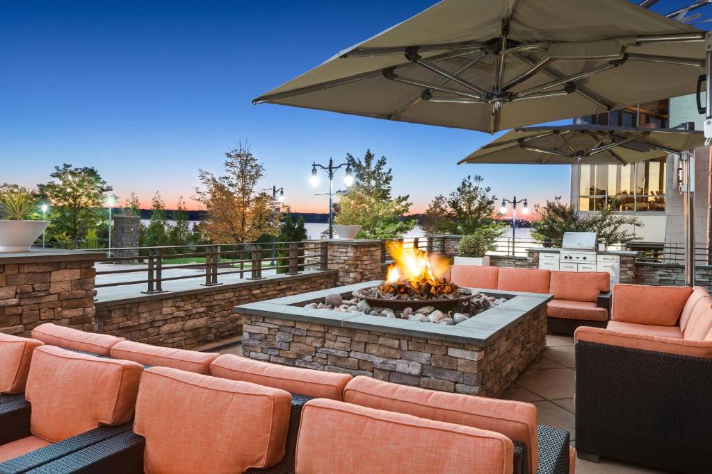 a patio with a fire pit with chairs and an umbrella at Residence Inn by Marriott National Harbor Washington, D.C. Area in National Harbor
