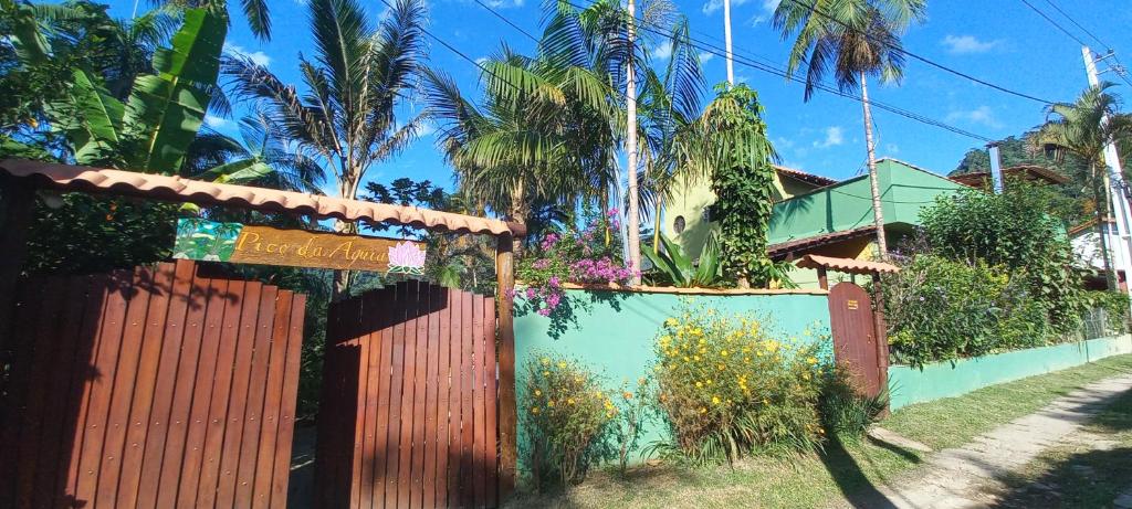 una recinzione di fronte a una casa con palme di Casa da Floresta Pico da Águia a Parati