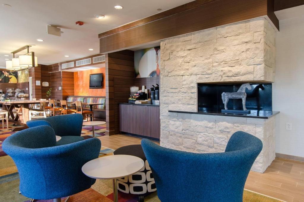 ウッドブリッジにあるFairfield Inn and Suites by Marriott Potomac Mills Woodbridgeの青い椅子と暖炉のあるロビー