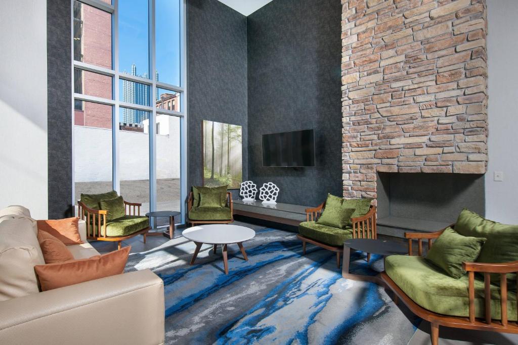 a living room with a couch and a fireplace at Fairfield by Marriott Pittsburgh Downtown in Pittsburgh