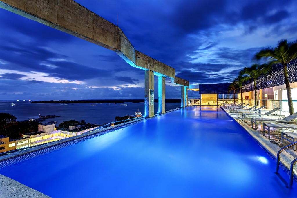 una piscina en la azotea de un edificio con el océano en Cosmos Pacifico Hotel en Buenaventura
