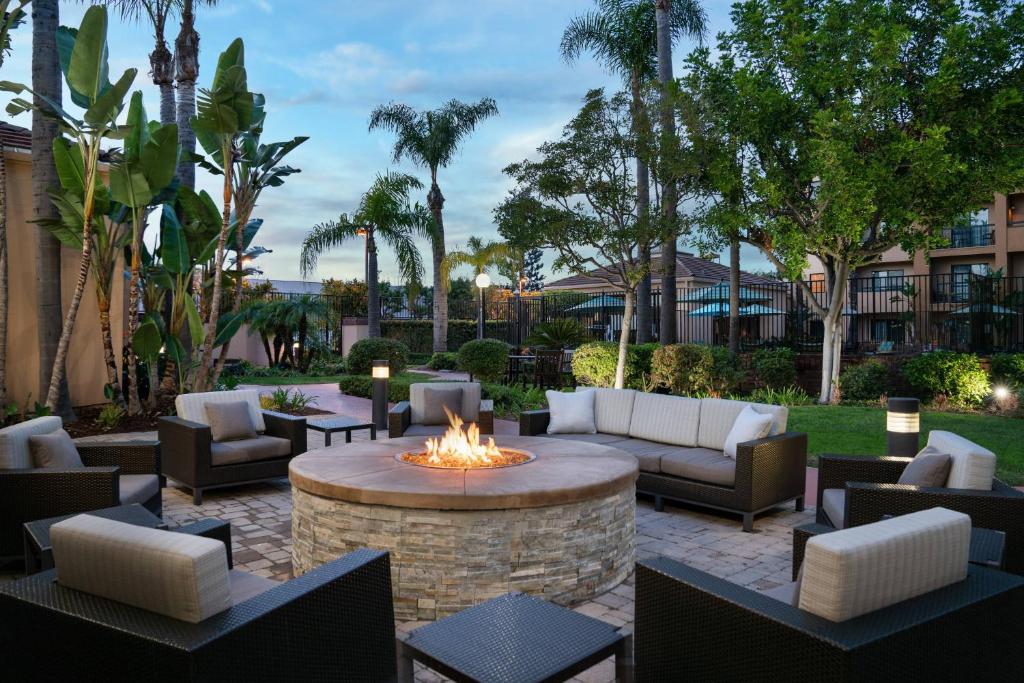 une terrasse avec un foyer extérieur, des canapés et des chaises dans l'établissement Courtyard Costa Mesa South Coast Metro, à Santa Ana